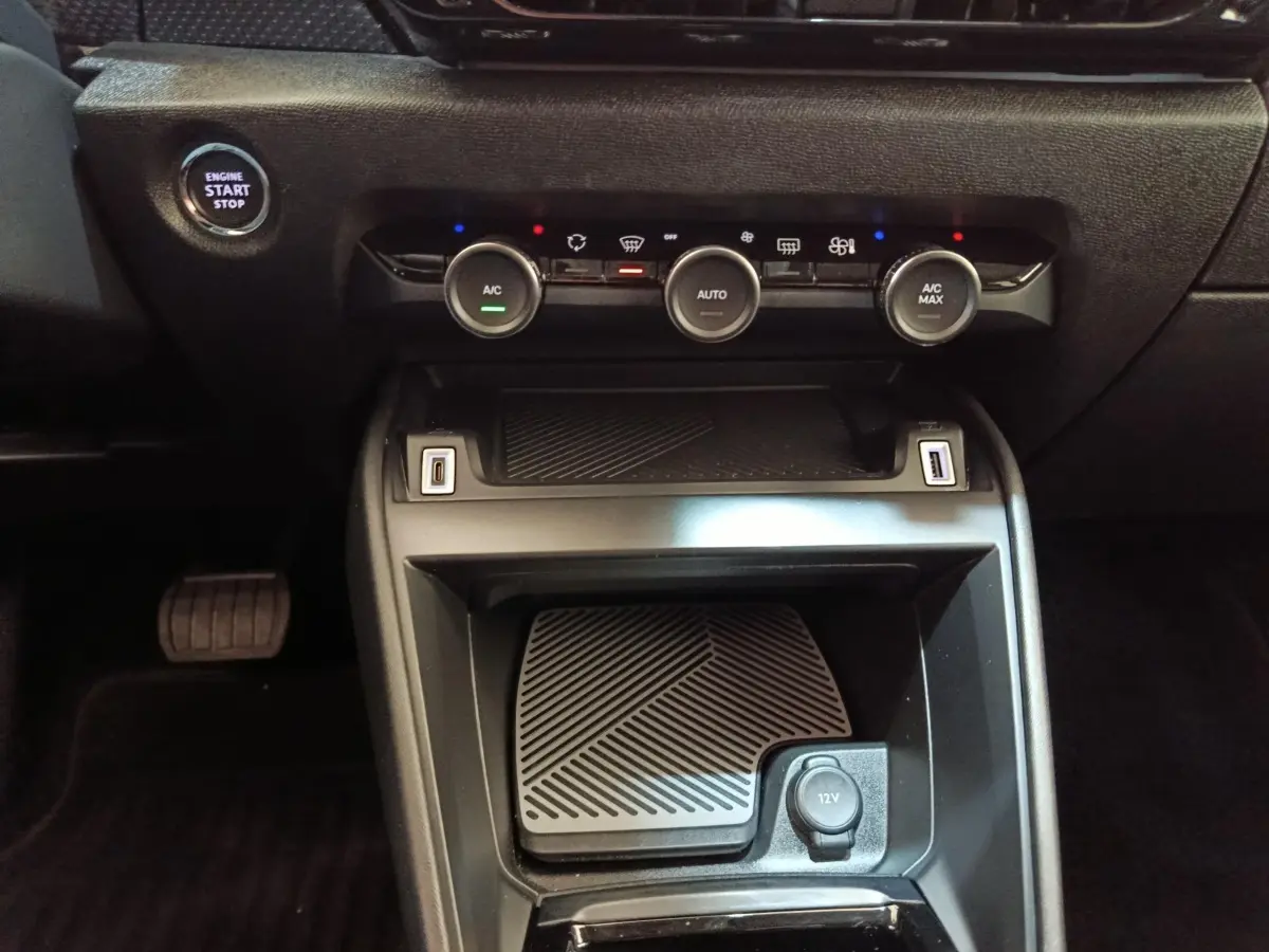 Vue rapprochée de la console centrale noire du Citroën C4 2022 avec commandes climatisation et bouton start/stop.