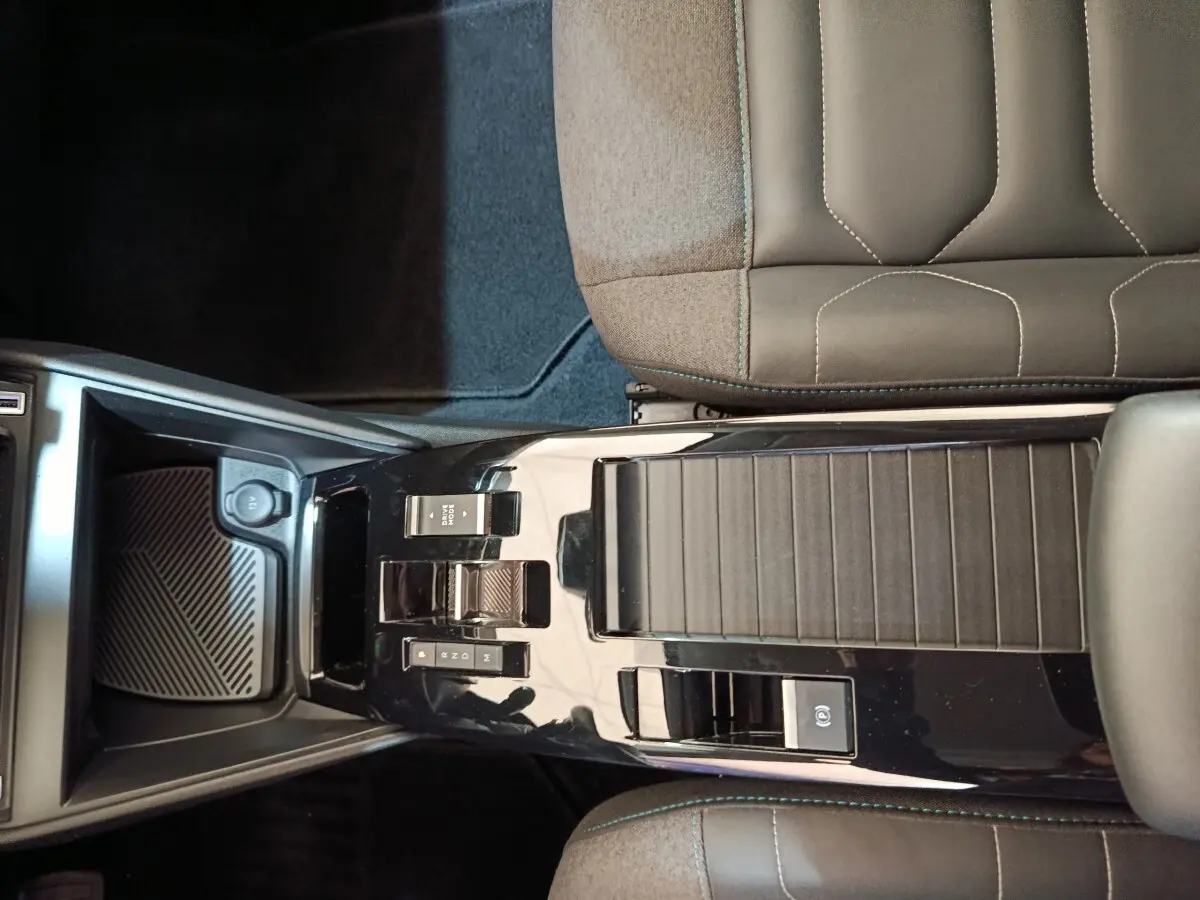 Vue plongeante sur la console centrale noire brillante et les sièges gris foncé de la Citroën C4 2022.