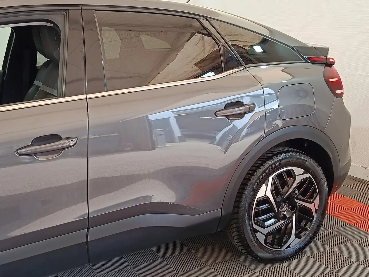 Vue latérale droite sur la partie arrière d'une Citroën C4 gris foncé avec jante alliage et porte de coffre visible.
