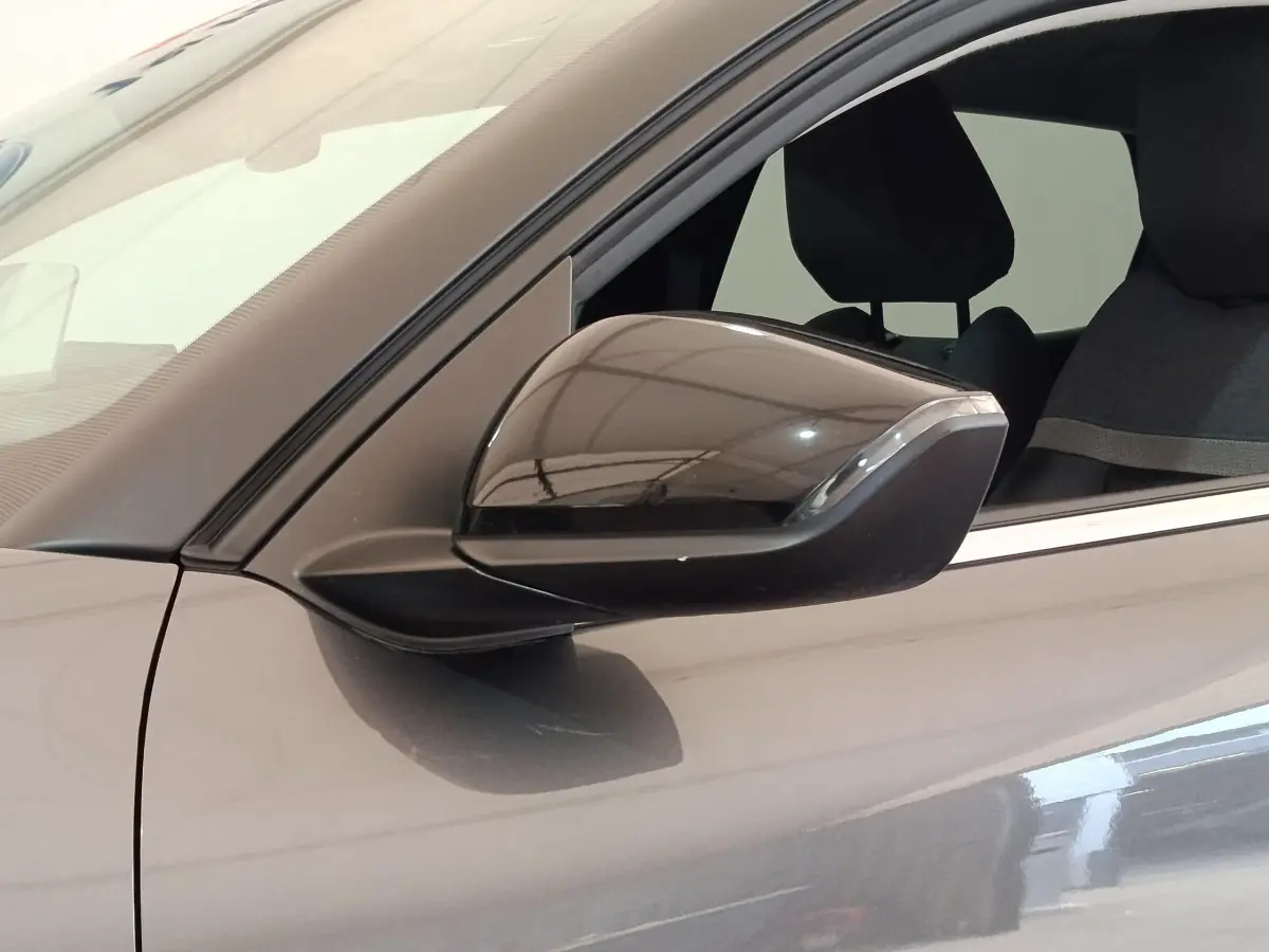 Rétroviseur côté gauche d'une Citroën C4 gris foncé 2022, avec partie de la portière et siège visible.