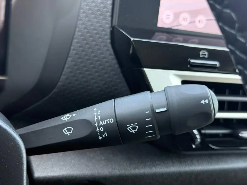 Gros plan sur la commande des essuie-glaces côté gauche du tableau de bord d'une Citroën C4 1.2 Hybride gris Mercury.