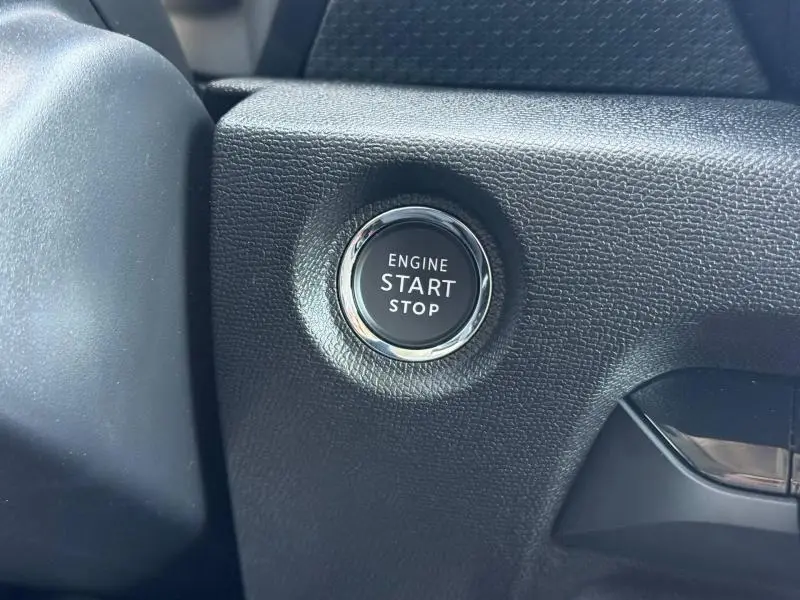 Gros plan sur le bouton moteur start/stop noir cerclé de chrome dans l'habitacle d'une Citroën C4 gris Mercury 2025.
