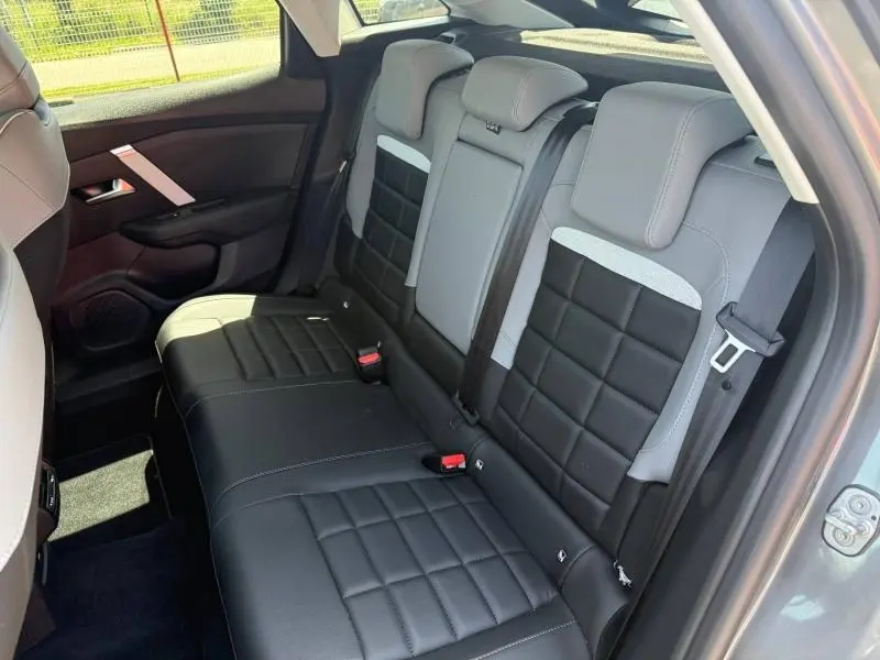 Vue intérieure arrière côté droit de la banquette cuir bicolore noire et grise du Citroën C4 1.2 Hybride 2025.