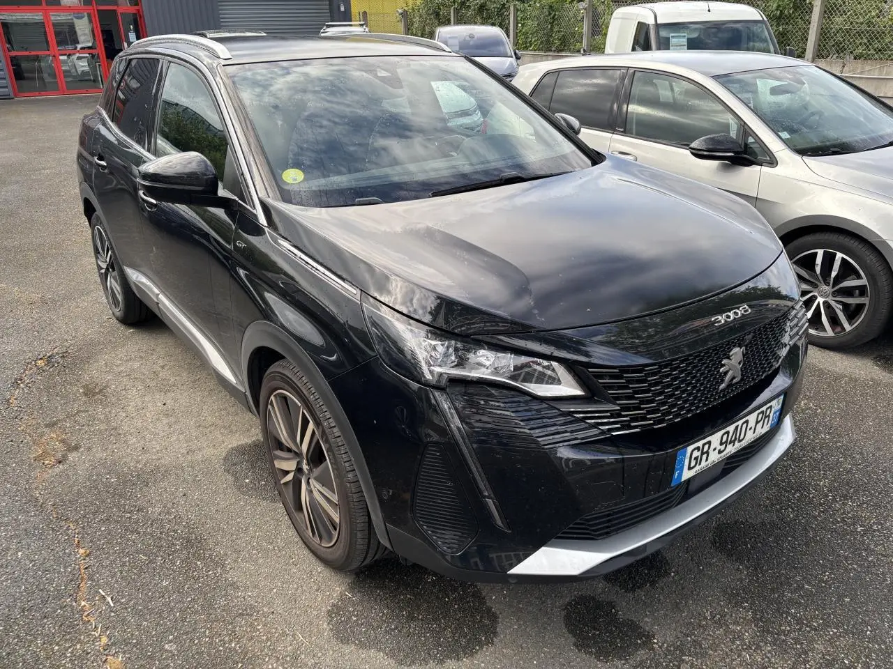 Peugeot 3008 noir métallisé vue 3/4 avant droit, avec jantes alliage bi-ton et calandre distinctive GT Pack.