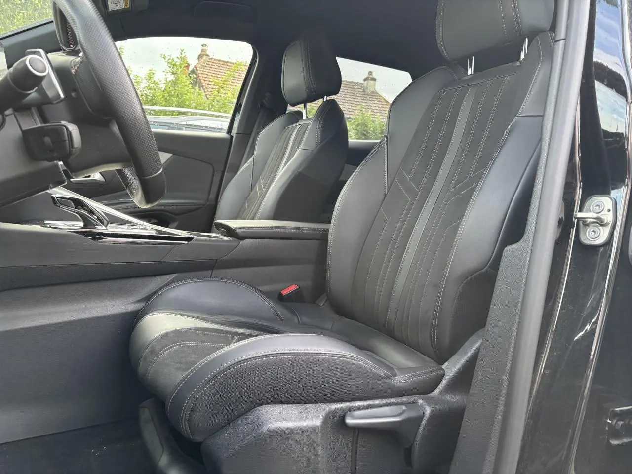 Vue intérieure côté conducteur du Peugeot 3008 noir, mettant en valeur le siège avant en cuir avec surpiqûres.