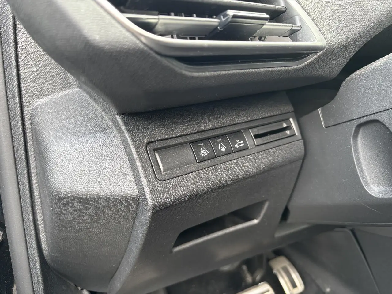 Détail intérieur côté conducteur du Peugeot 3008 noir, avec commandes d'assistance et bouche d'aération.