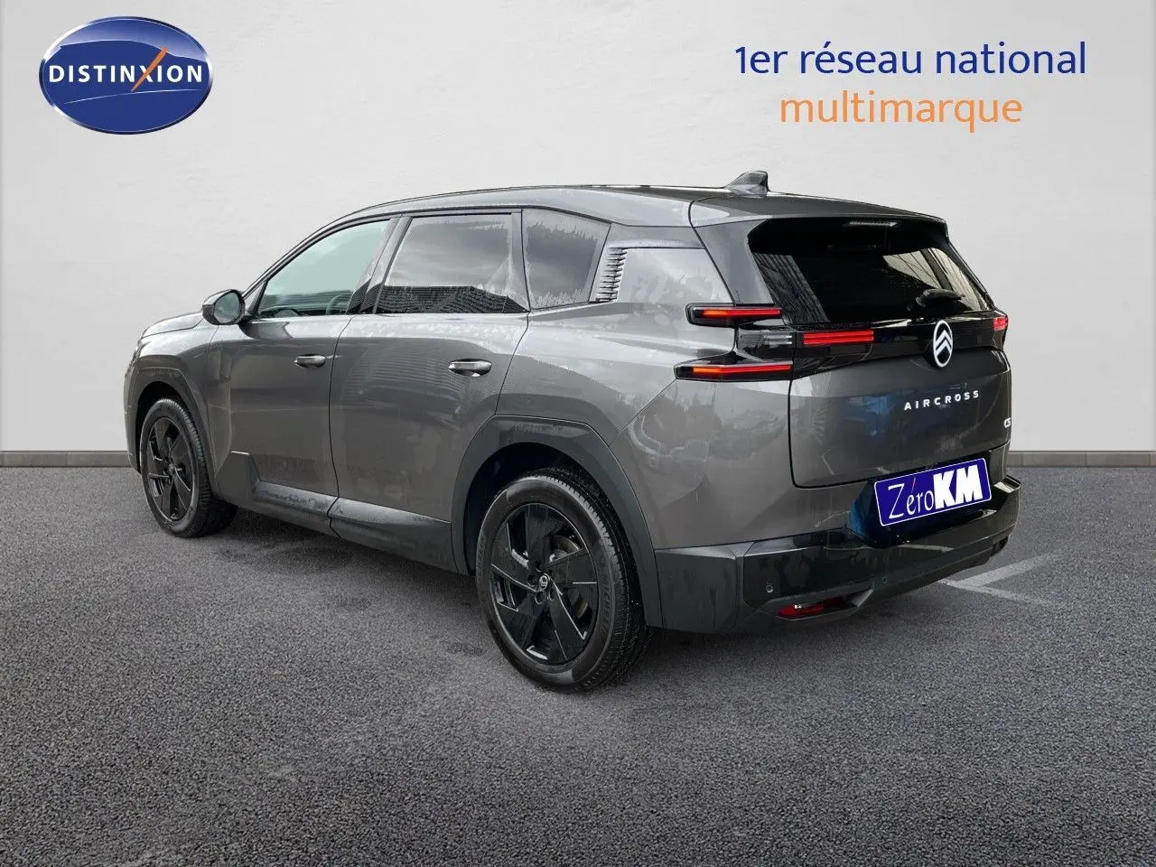 Vue 3/4 arrière droite d'un Citroën C5 Aircross Hybrid gris platinium métal avec jantes noires et feux arrière LED fins.