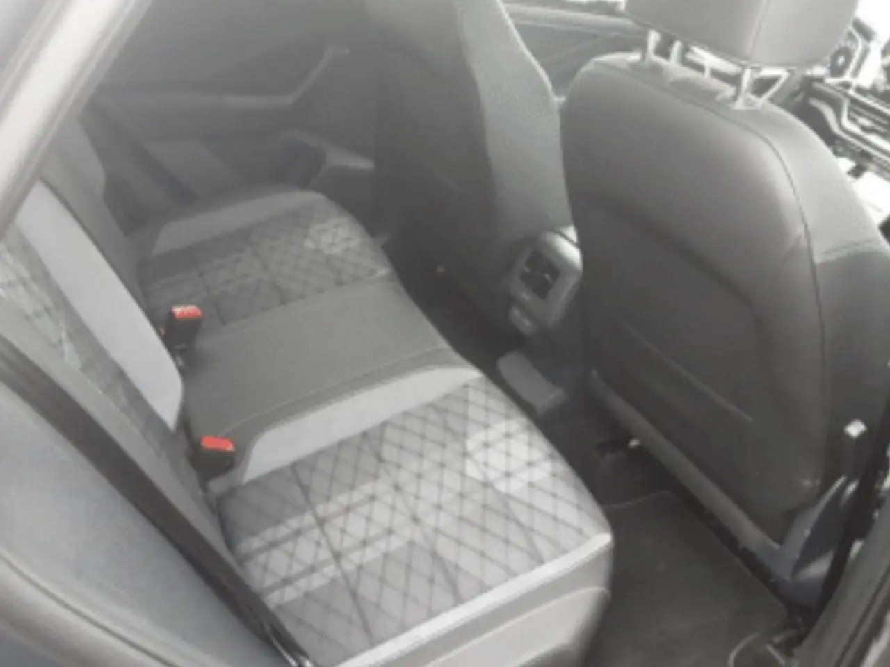 Vue intérieure du siège arrière droit du Volkswagen T-Roc 2025 avec sellerie tissu gris à motifs géométriques.