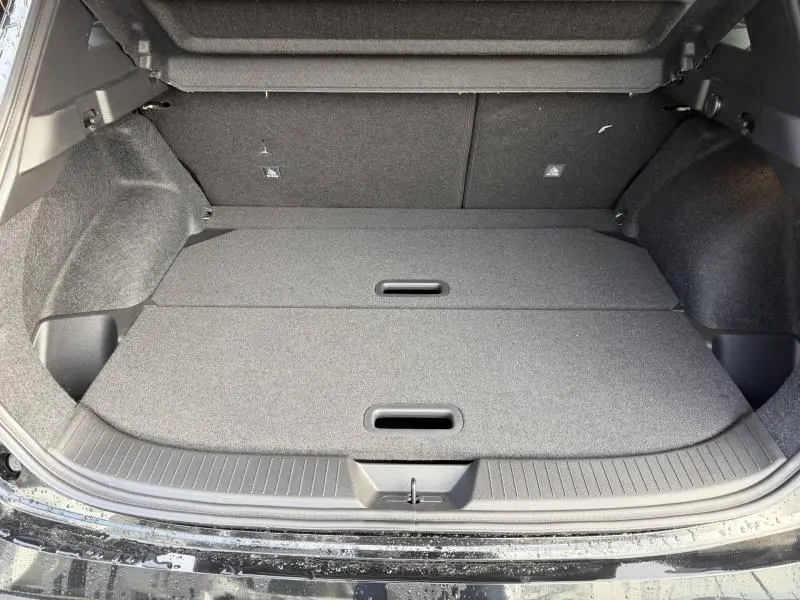 Coffre ouvert vu de l'arrière d'un Nissan Qashqai Hybrid e-POWER 2025 noir, montrant un espace de chargement plat et doublé.