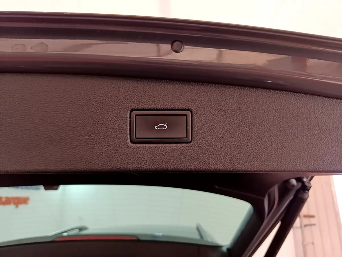 Bouton d'ouverture électrique du coffre sur le hayon intérieur d'un Volkswagen Tiguan gris clair 2021.