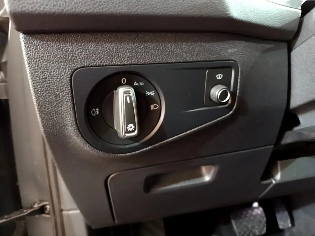 Gros plan sur le panneau de commande des phares à gauche du volant dans le Volkswagen Tiguan gris clair 2021.