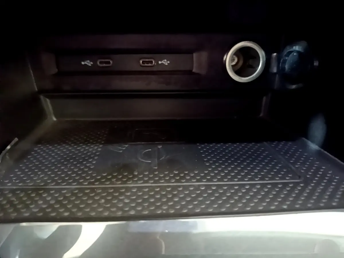 Gros plan sur la zone de recharge sans fil et ports USB-C dans le coffre du Volkswagen Tiguan gris clair 2021.