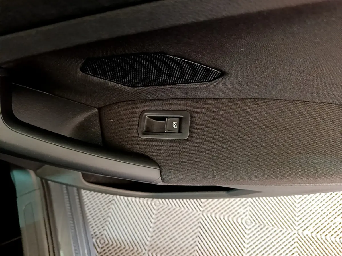 Détail de la poignée intérieure de porte arrière côté droit du Volkswagen Tiguan gris clair 2021.