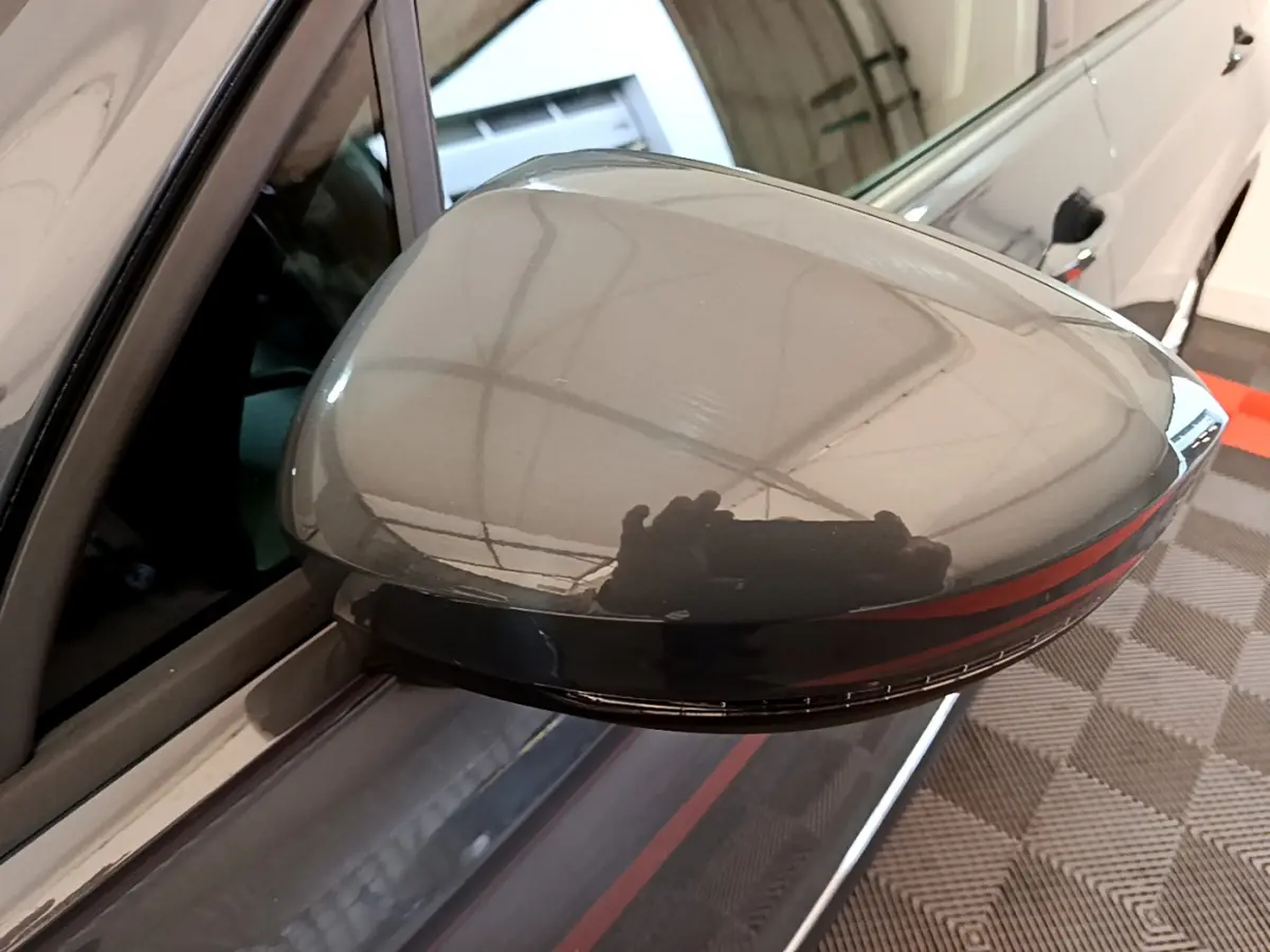 Rétroviseur droit gris clair du Volkswagen Tiguan 2021 avec clignotant LED intégré, vue rapprochée en intérieur.