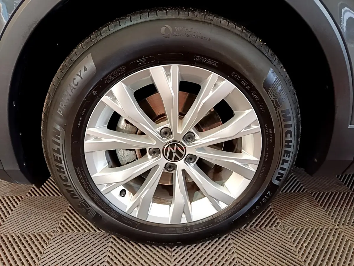 Gros plan sur la roue avant droite du Volkswagen Tiguan gris clair avec jante alliage et pneu Michelin.