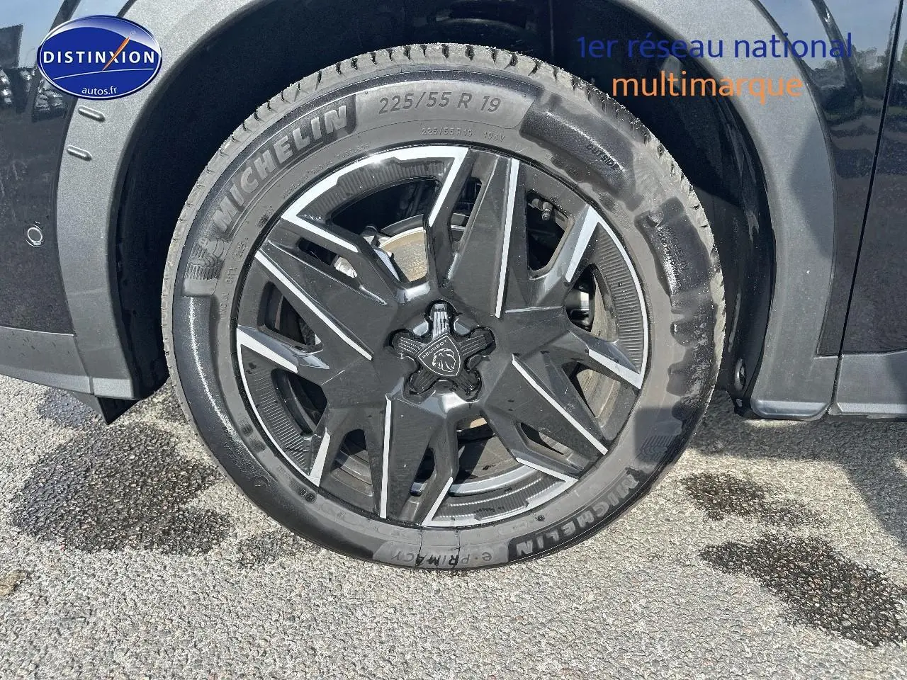 Gros plan sur la roue avant droite noire avec jante alu au design moderne du Peugeot 3008 1.2 hybrid 145 allure 2025.