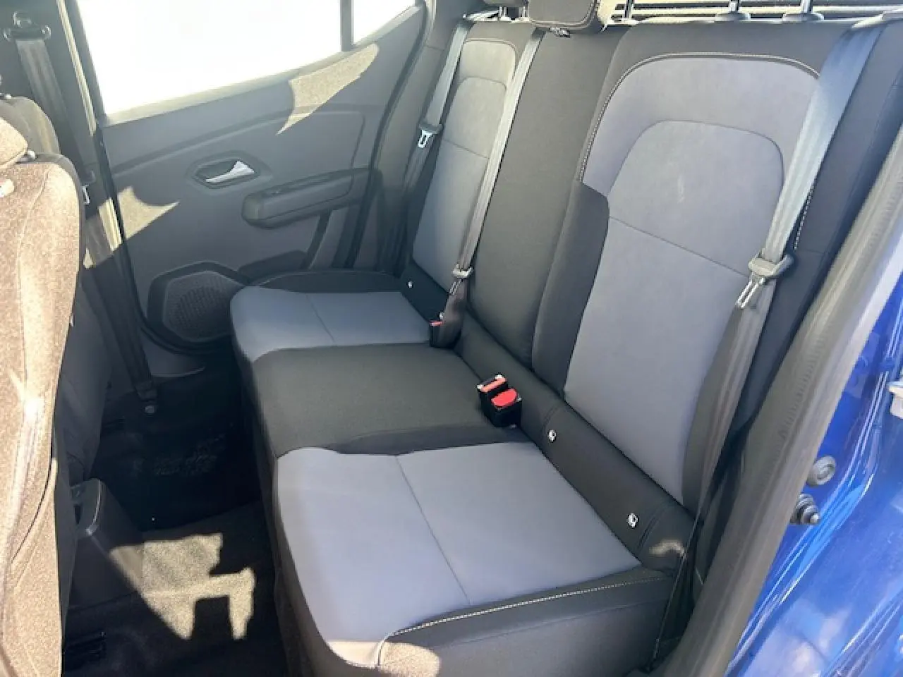 Vue intérieure côté droit de la banquette arrière bicolore gris et noir du Dacia Sandero III Stepway bleu Iron.