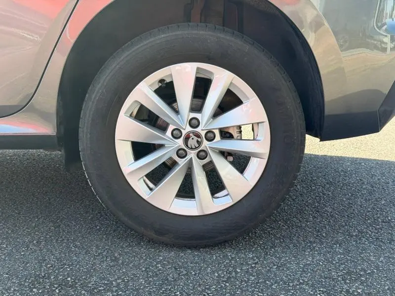 Gros plan sur la roue avant gauche du Skoda Kamiq 2025 gris graphite métallisé avec jante alliage à plusieurs branches.