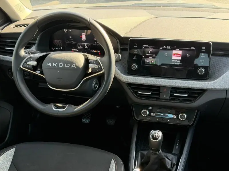 Vue intérieure du tableau de bord et volant SKODA KAMIQ 2025, avec écran tactile et levier de vitesses manuel.
