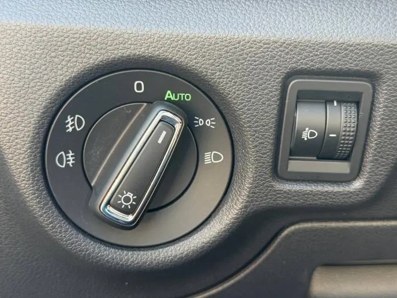 Gros plan sur le sélecteur de feux avec réglage automatique dans l’habitacle du Skoda Kamiq gris Graphite métallisé.
