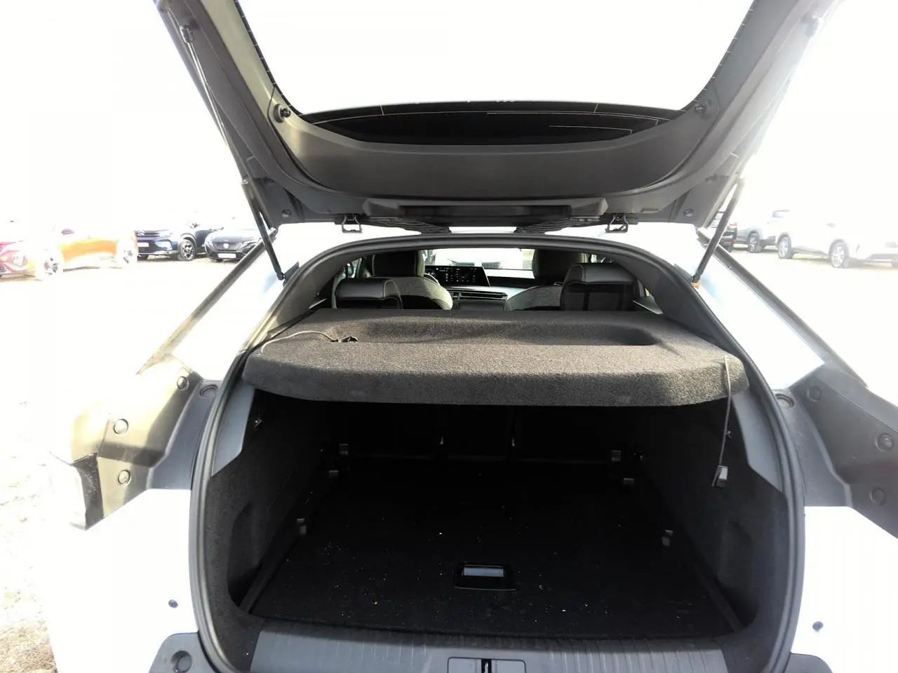 Vue arrière du coffre ouvert d'un Peugeot 3008 blanc, montrant l'espace de chargement et l'intérieur sombre.