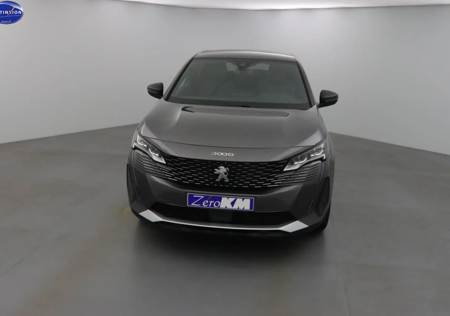 Vue frontale d'un Peugeot 3008 gris platinium métallisé avec calandre noire et phares LED modernes.