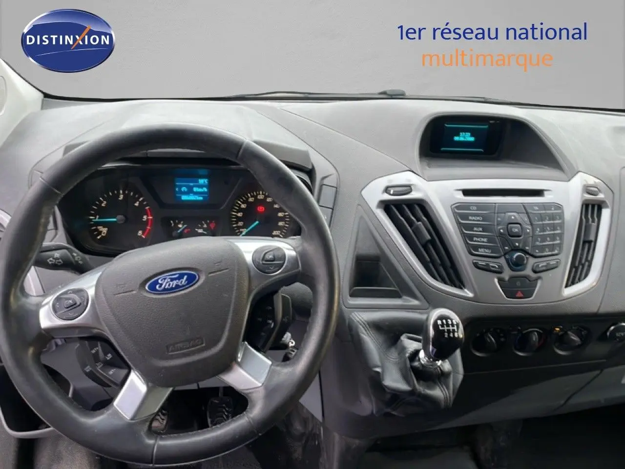 Vue intérieure du tableau de bord du Ford Transit Custom blanc 2016, avec volant et levier de vitesses manuel visibles.