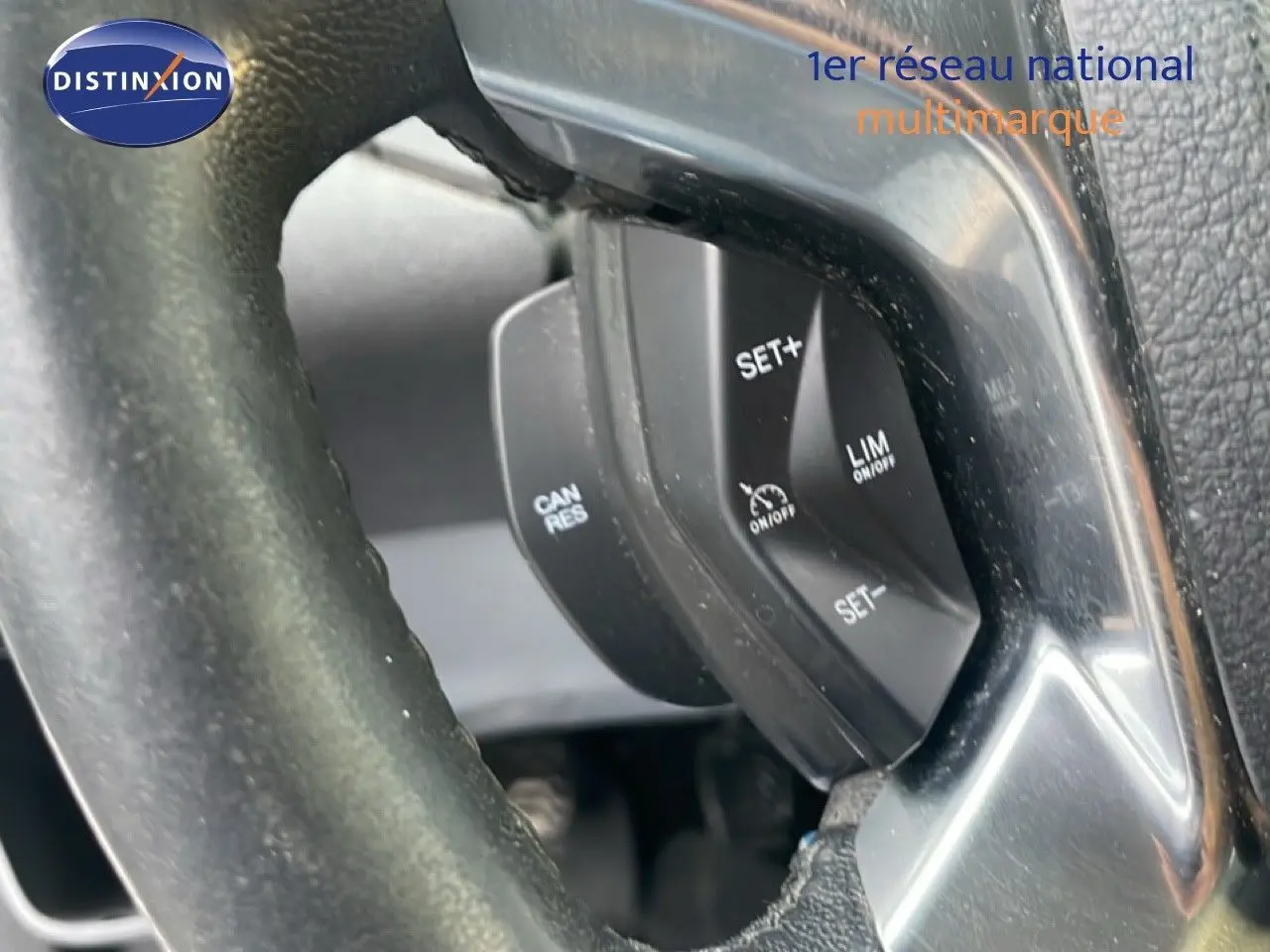 Gros plan sur les commandes de régulateur de vitesse au volant noir du Ford Transit Custom blanc L1H1 2016.