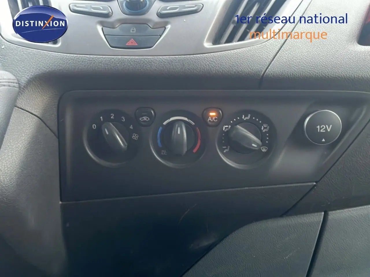 Tableau de bord noir du Ford Transit Custom L1H1 2016 montrant les commandes de climatisation et prise 12V.