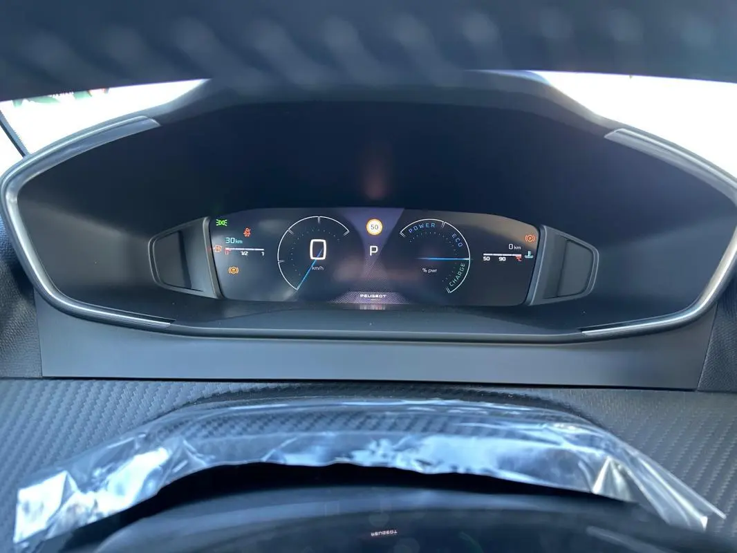 Vue rapprochée du cockpit numérique de la Peugeot 208 Hybrid 110, affichage digital clair et moderne.