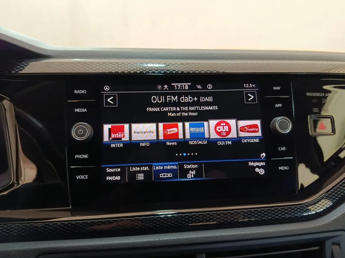 Écran tactile central du Volkswagen Taigo 2023 affichant la radio DAB+ avec commandes physiques autour, vue de face.