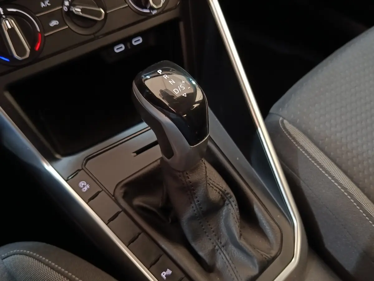 Le levier de vitesse automatique noir du Volkswagen Taigo 1.0 TSI 110 DSG Life Plus, vue rapprochée côté console centrale.