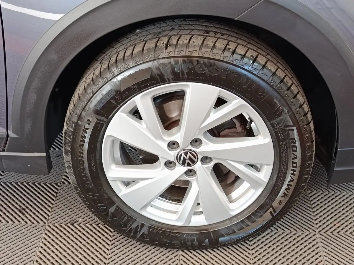 Gros plan sur la roue avant gauche du Volkswagen Taigo gris foncé avec jante alliage et pneu Firestone Roadhawk.