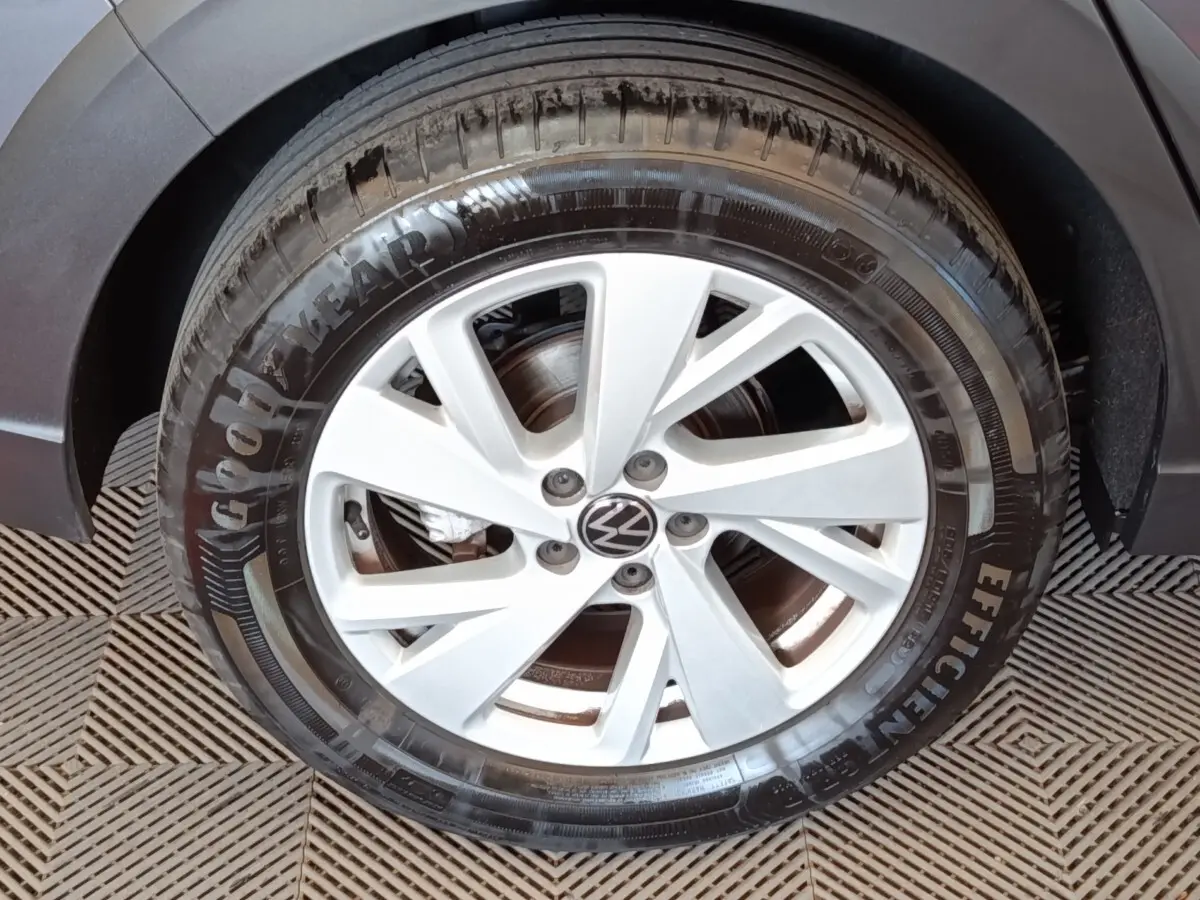 Gros plan sur la roue avant gauche de la Volkswagen Taigo gris foncé avec jante alliage à 5 branches doubles.