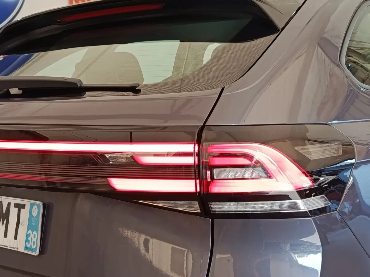 Feu arrière droit allumé d'un Volkswagen Taigo gris foncé, vue rapprochée de l'arrière du véhicule.