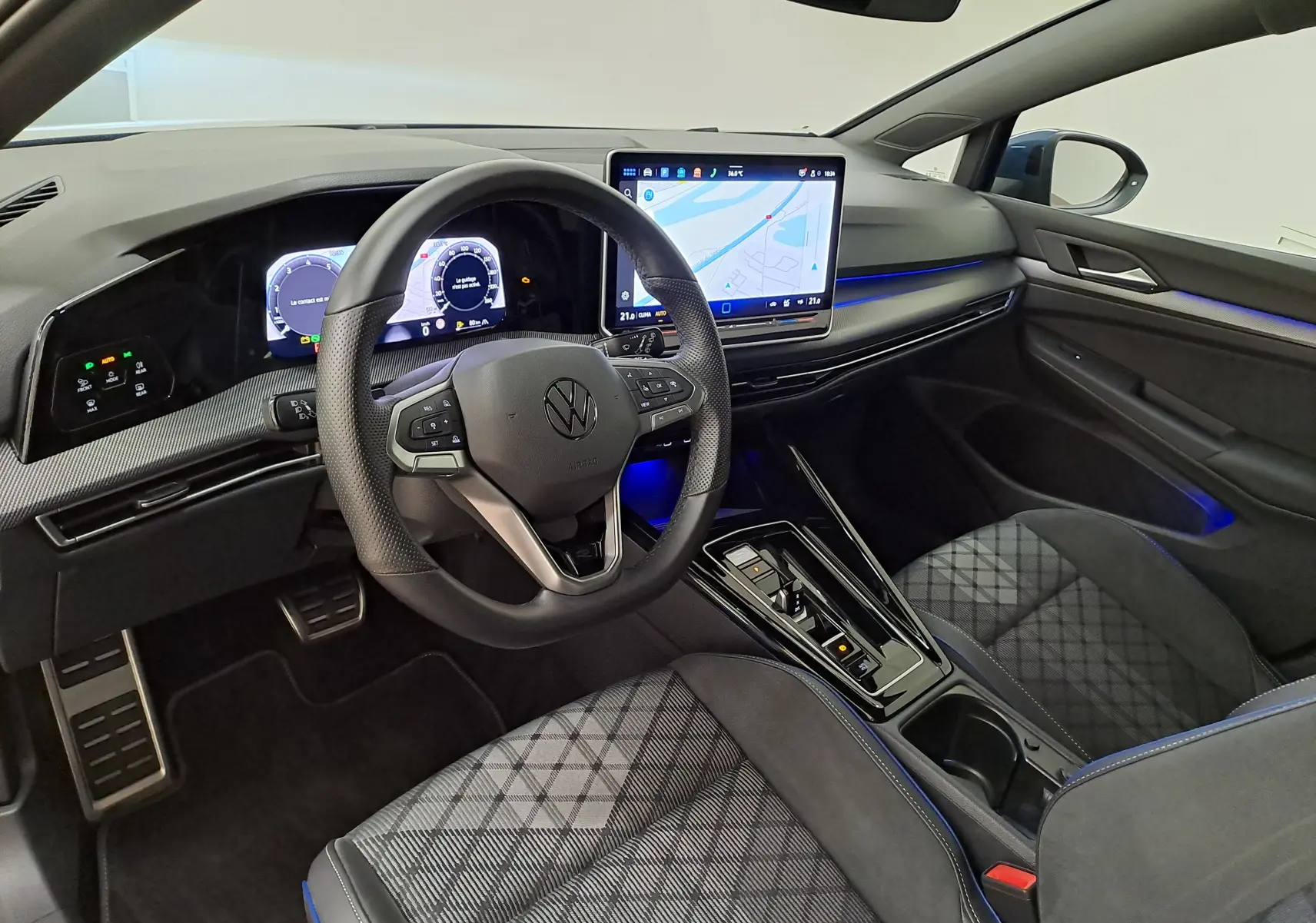 Vue intérieure côté conducteur de la Volkswagen Golf 1.5 eTSI R-Line 2025 avec tableau de bord numérique et écran tactile central.