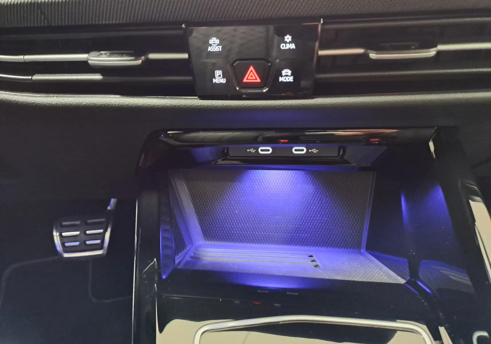 Détail de la console centrale de la Volkswagen Golf 1.5 eTSI 150 DSG7 R-Line avec éclairage bleu et ports USB-C visibles.