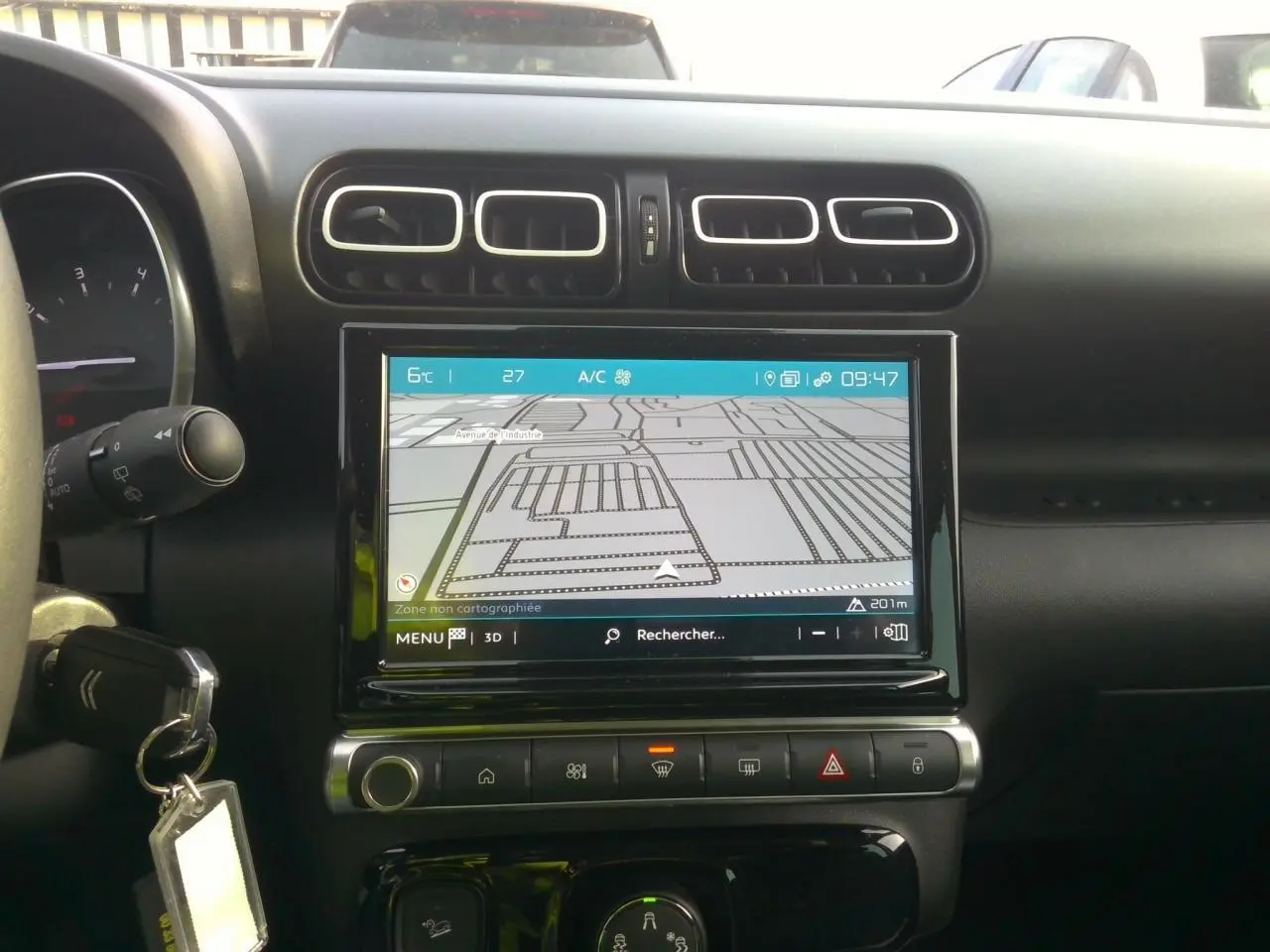 Vue intérieure centrée sur l'écran tactile de navigation et les aérateurs du tableau de bord noir du Citroën C3 Aircross.