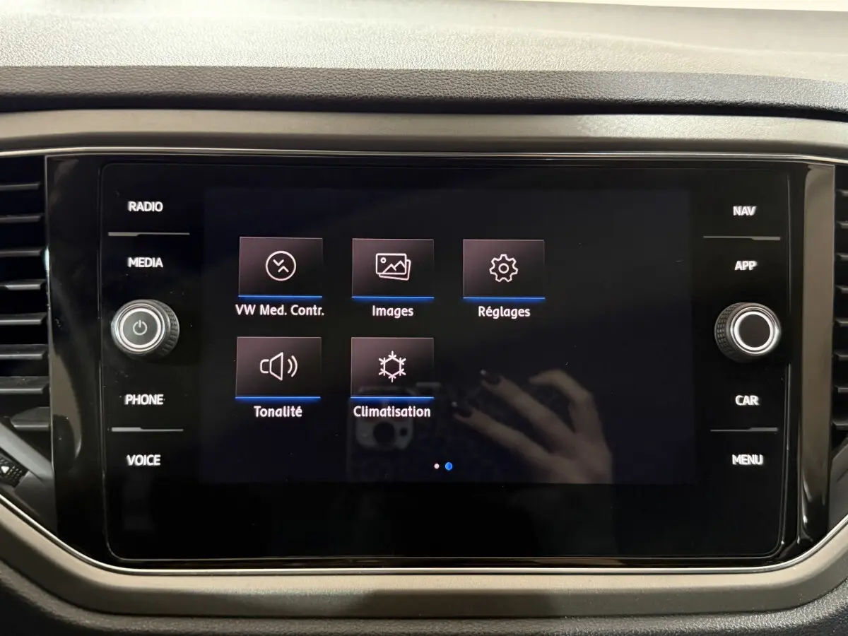 Écran tactile central du Volkswagen T-Roc blanc 2020 affichant les options média, images, réglages, tonalité et climatisation.