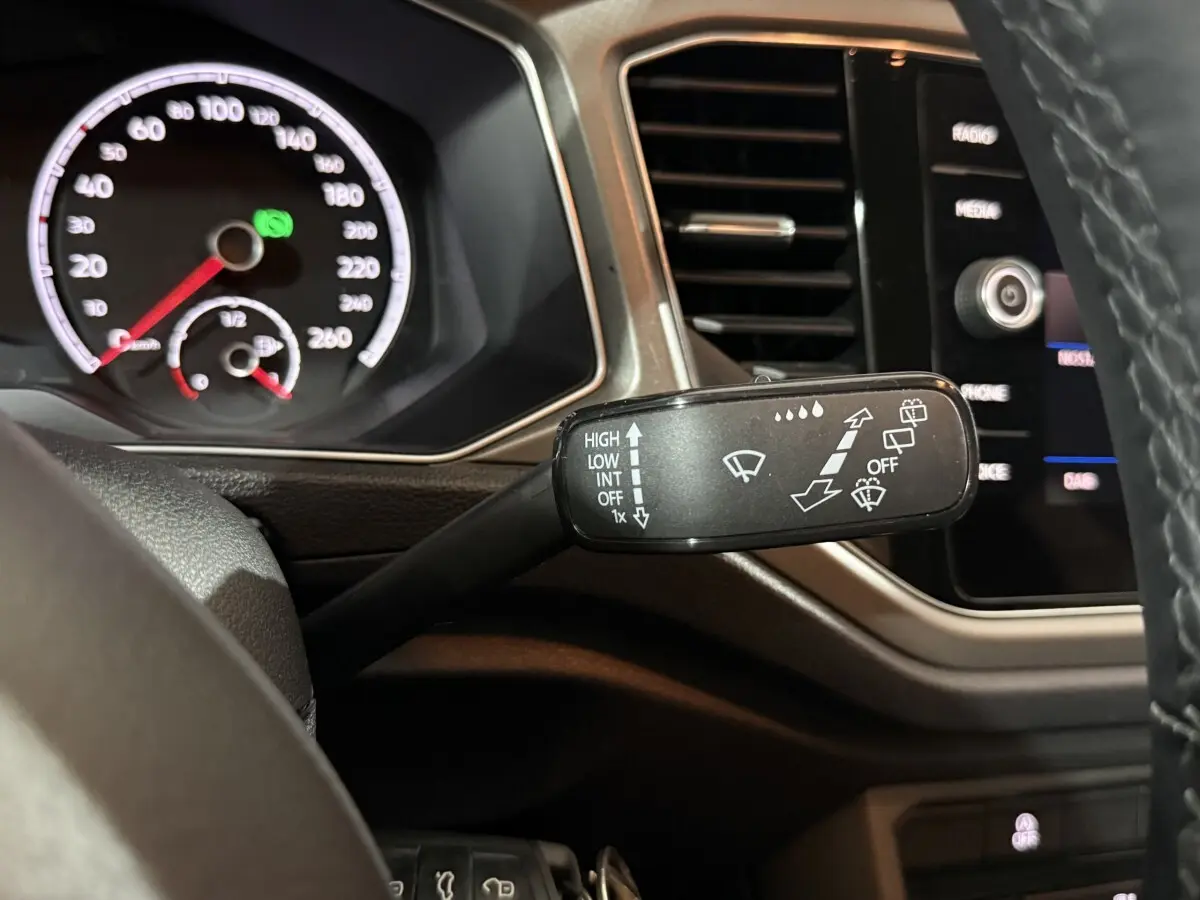 Gros plan sur la manette d'essuie-glace à gauche du volant dans l'habitacle du Volkswagen T-Roc blanc 2020.