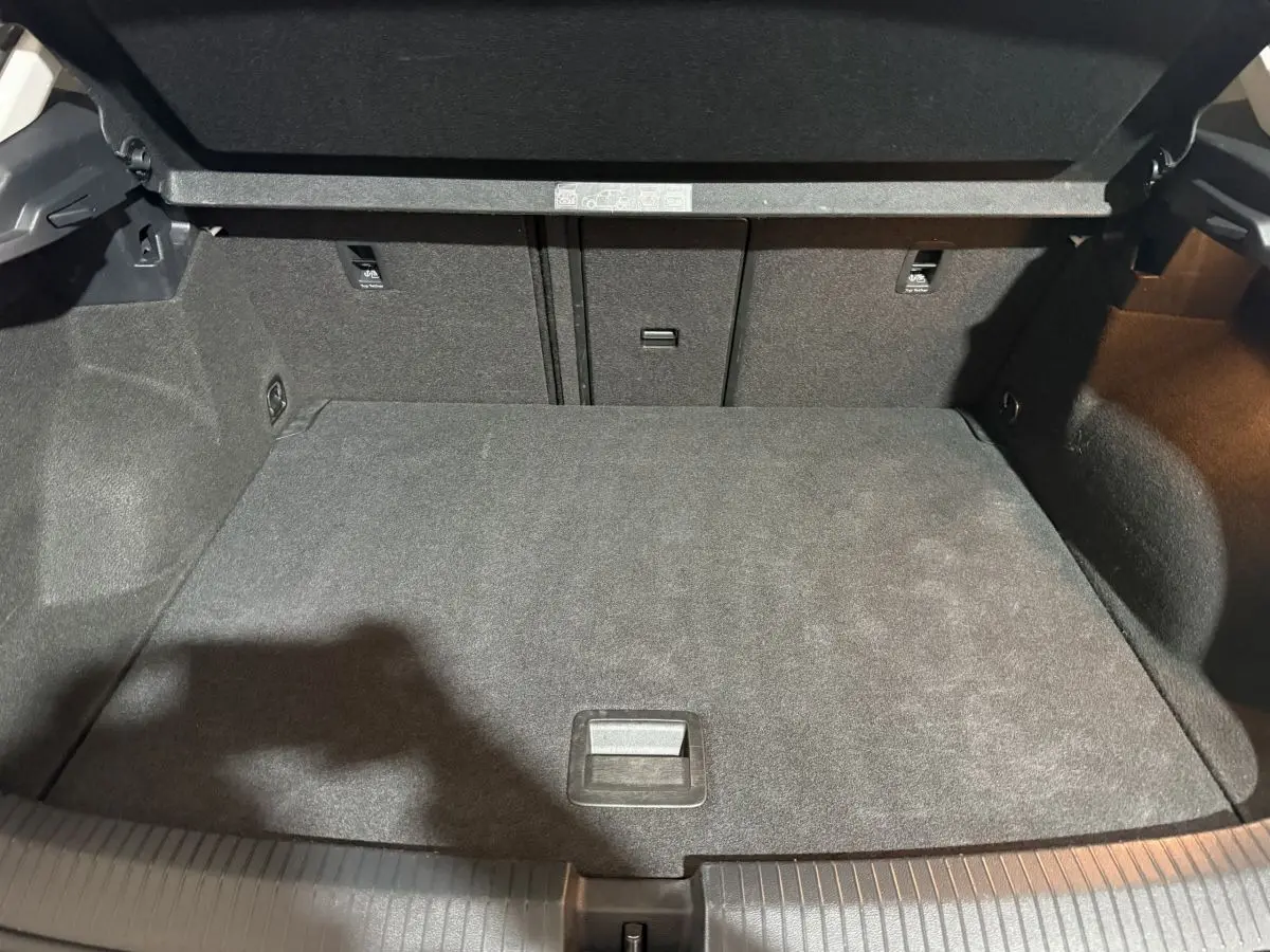 Coffre ouvert du Volkswagen T-Roc blanc 2020, montrant un espace de chargement propre et bien fini en tissu noir.