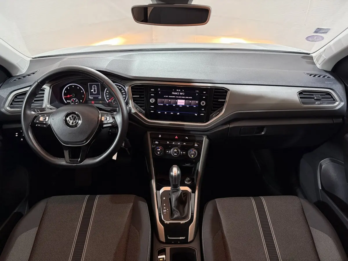 Intérieur du Volkswagen T-Roc 2020, tableau de bord et console centrale avec écran tactile et volant cuir noir.