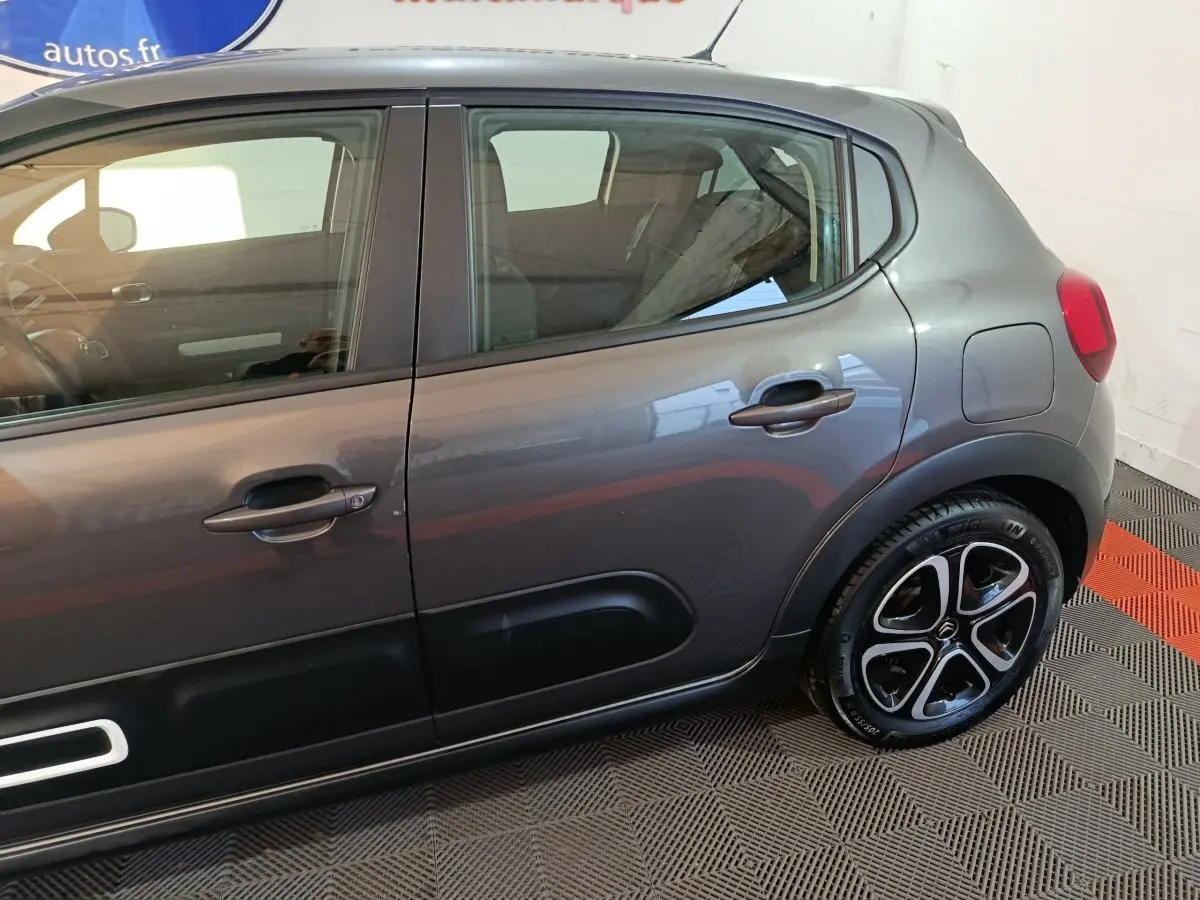 Vue latérale droite d'une Citroën C3 gris foncé 2024 avec jantes noires et inserts noirs sur les portes.