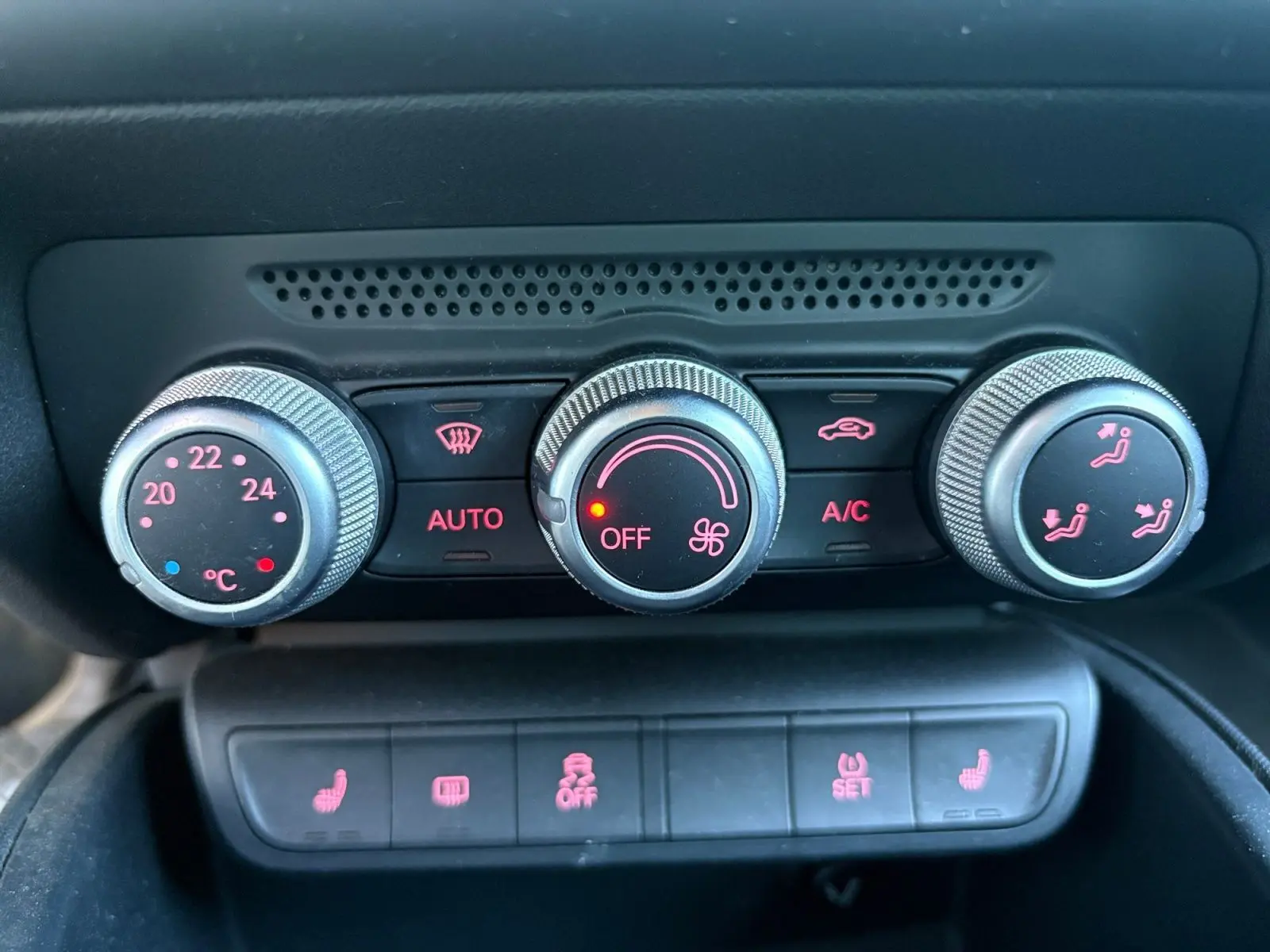 Gros plan sur la commande de climatisation automatique et les boutons des sièges chauffants d'une Audi A1 Sportback grise.