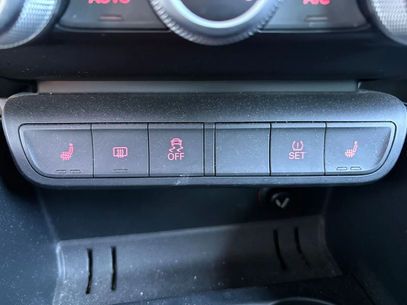Gros plan sur les boutons de commande du tableau de bord de l'Audi A1 Sportback grise, avec sièges chauffants activés.