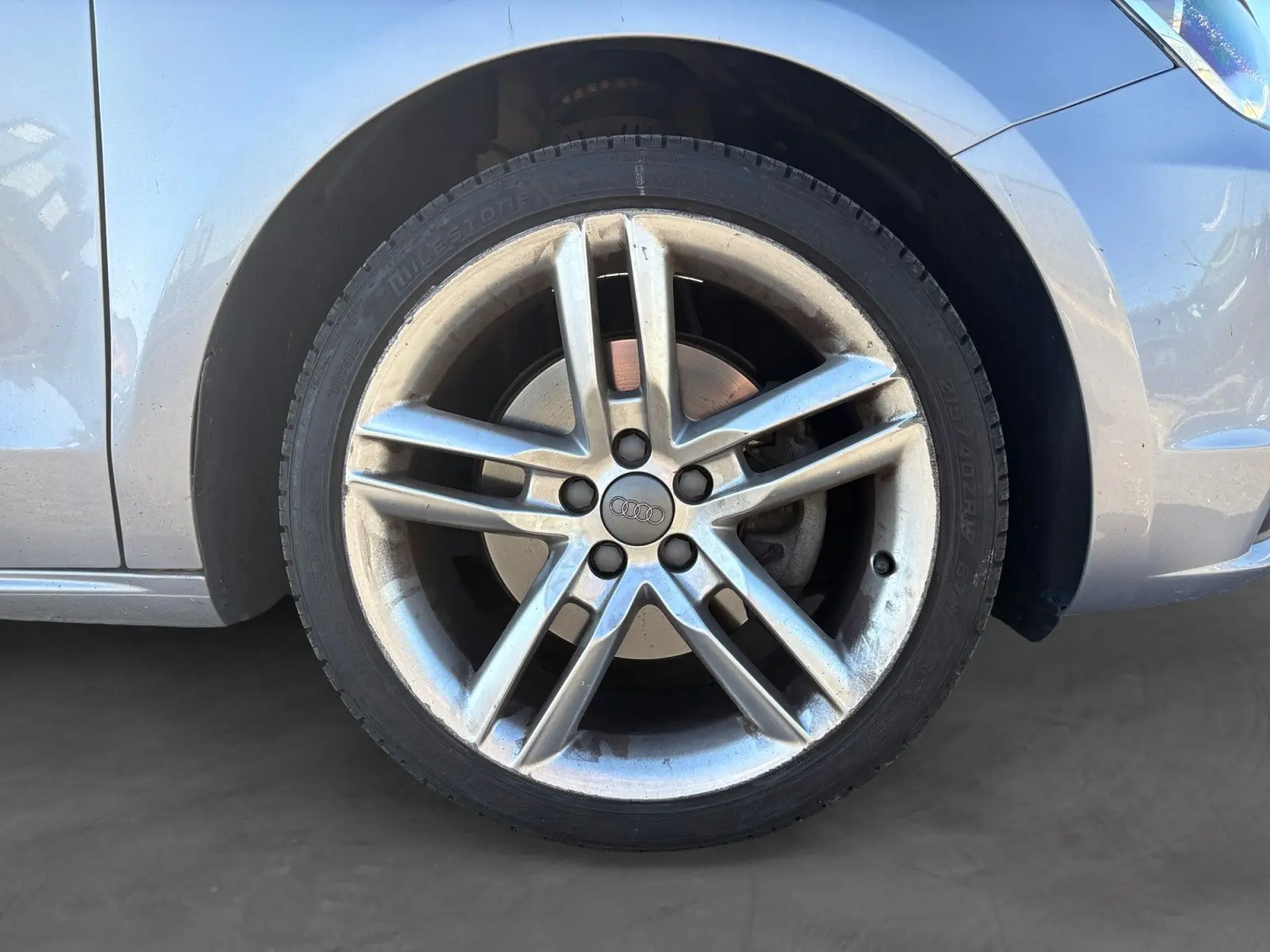 Gros plan sur la roue avant droite grise d’une Audi A1 Sportback 2014 avec jante alliage cinq branches.