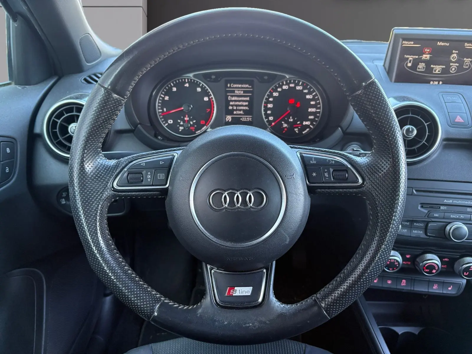 Vue centrée sur le volant sport S-Line noir avec tableau de bord et écran multimédia de l'Audi A1 Sportback 2014.