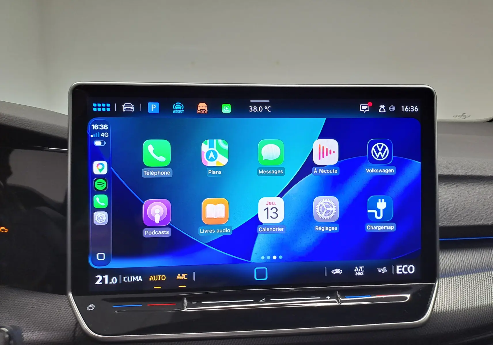 Écran tactile central de la Volkswagen Golf 1.5 eHybrid 2025 affichant les applications connectées et la climatisation à 21°C.