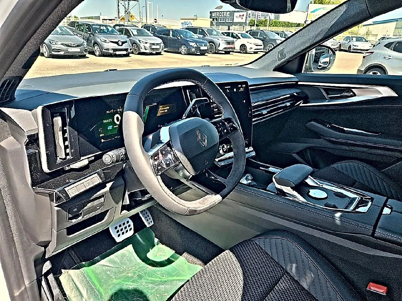 Vue intérieure côté conducteur du Renault Austral 1.2 e-tech hybride, avec volant multifonction et finition noire élégante.