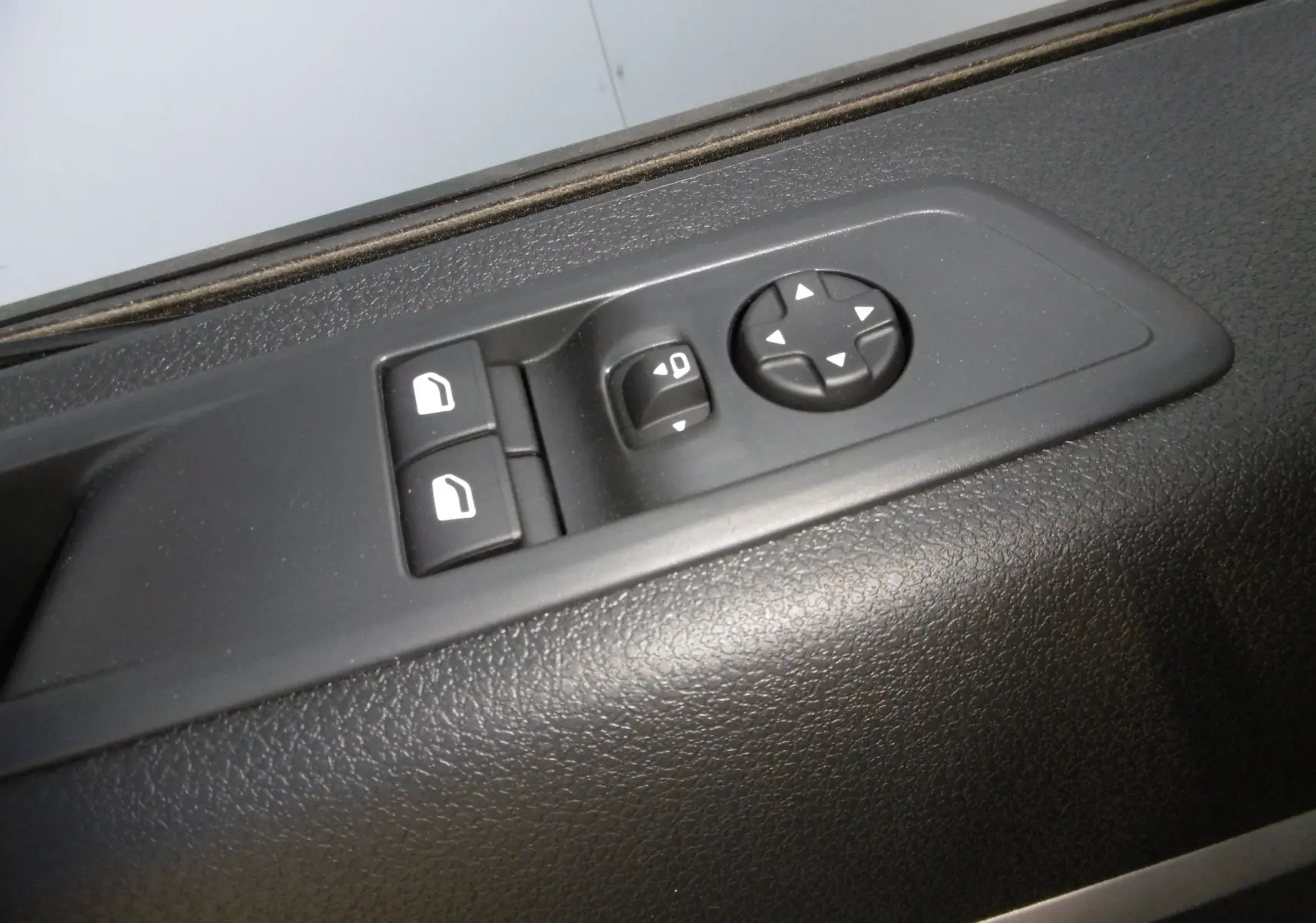 Gros plan sur les commandes de réglage des rétroviseurs et des vitres côté conducteur du Peugeot Expert Blanc 2023.